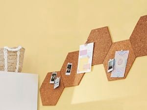 Corkboard organiser with photos pinned to it.
