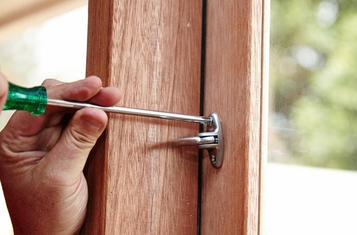 Using a screwdriver to screw the handle in place