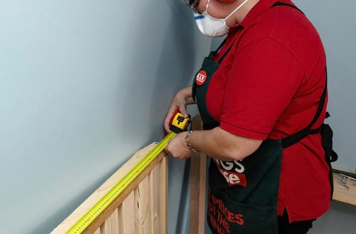 Person measuring length of bed frame