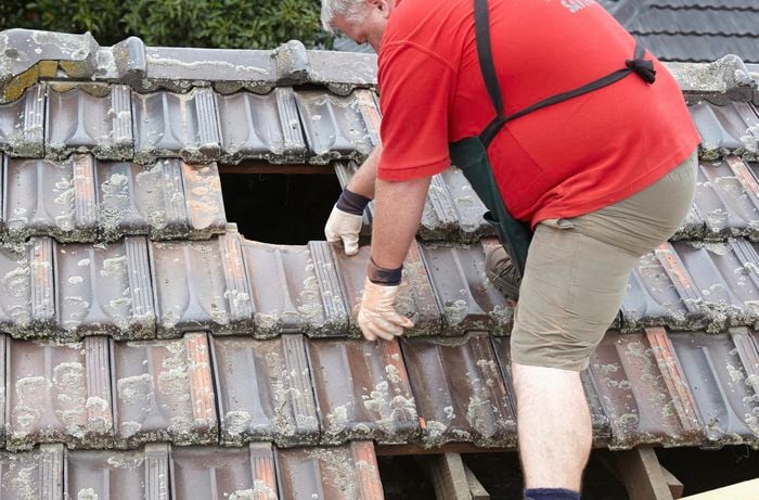 Tiles being removed from a roof to make way for a new skylight