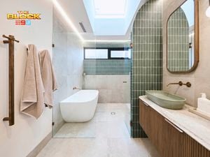 Green and white coloured bathroom with a timber fluted profile vanity and marble benchtop and bath