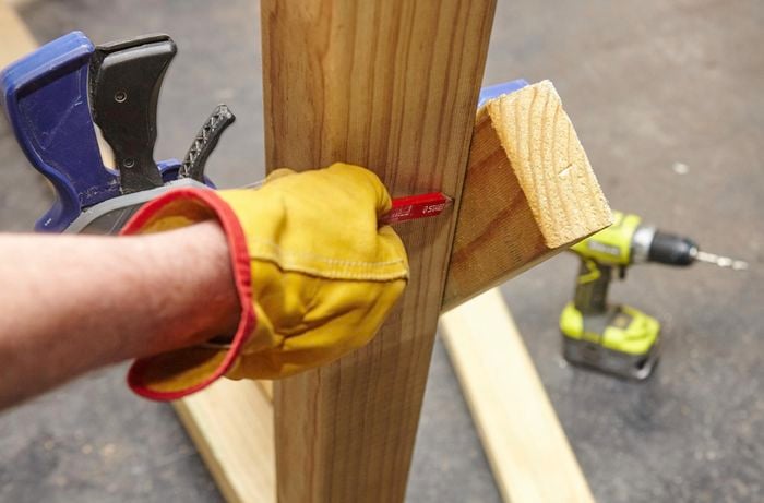 Person marking against two pieces of timber that are attached.