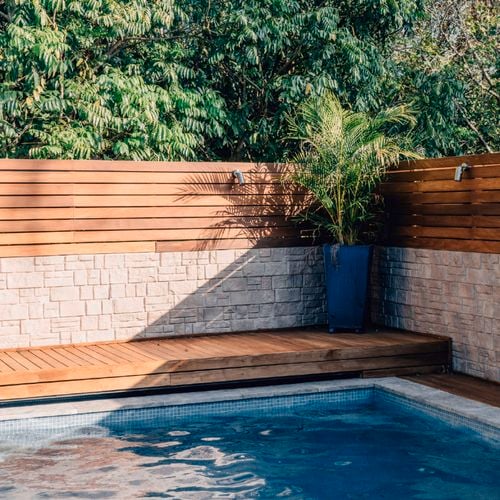 Poolside area with timber deck and potted plant