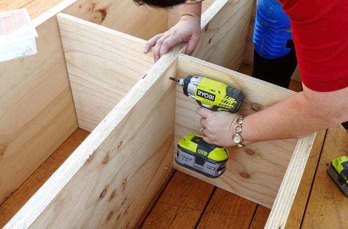 A hole being drilled into a laundry basket dresser frame
