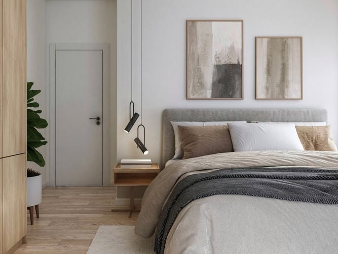 Modern bedroom featuring grey fabric bed, pendant lighting and artwork.
