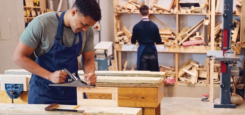 Two people working in a carpentry workshop