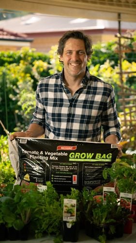 Man with growbag and plants. 