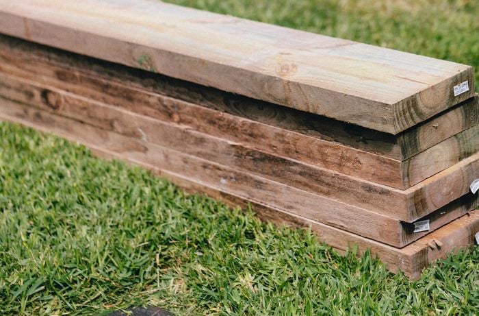 Wooden sleepers in a pile on grass