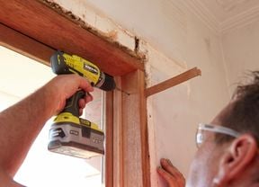 Drilling pilot holes at the top of the window frame