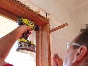 Drilling pilot holes at the top of the window frame