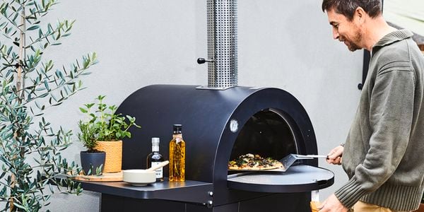 Pizza oven being used by man