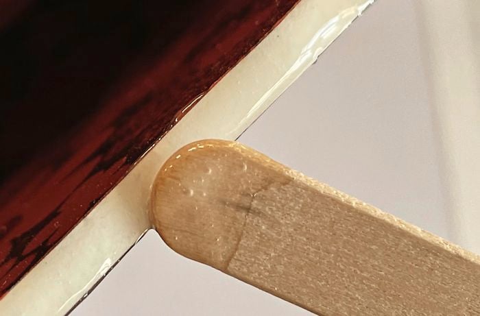 Craft stick used to apply a clear glue to a broken plate