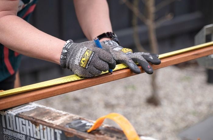 Person measuring the slats with tape measure and marking with pencil.