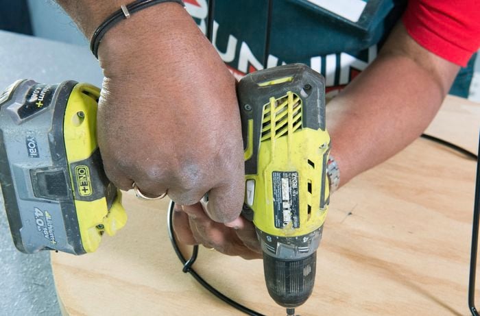Person attaching table base to tabletop