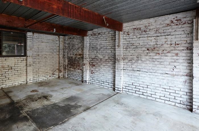 Old, dirty garage with oil stains on the ground.