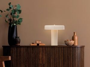 Wooden cabinet with decorative items and a flat shaped lamp lit up