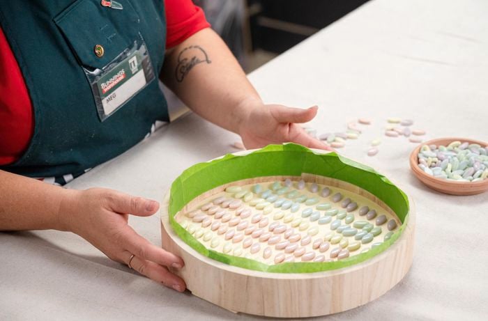 A Bunnings Team member holding a top of a side table with mosaic pieces on it