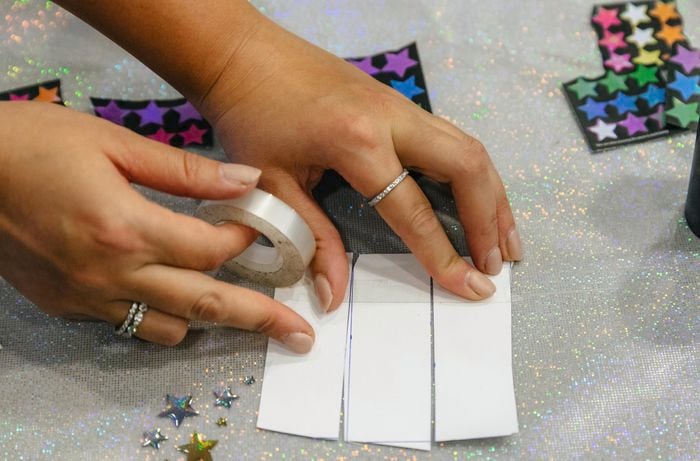 Cardboard rectangles being taped together with sticky tape