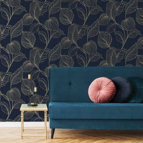 Blue colour sofa and a small side table in front of a Boutique wallpaper wall.