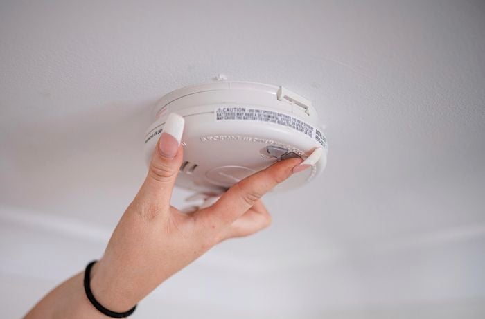 person closing a smoke alarm