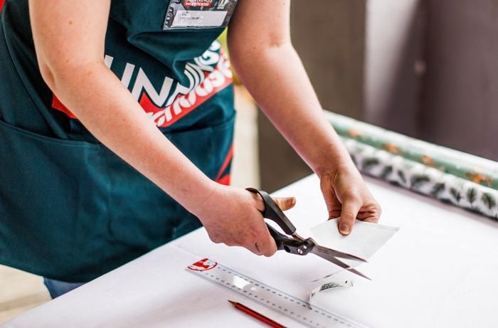 person cutting a piece of paper with scissors