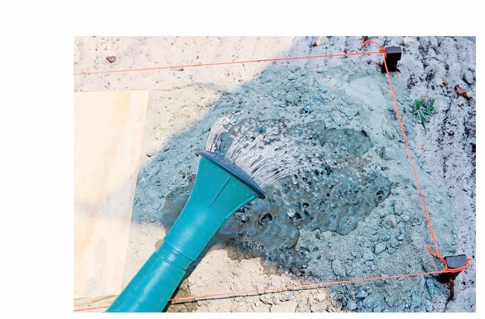 Concrete mix being saturated with a watering can