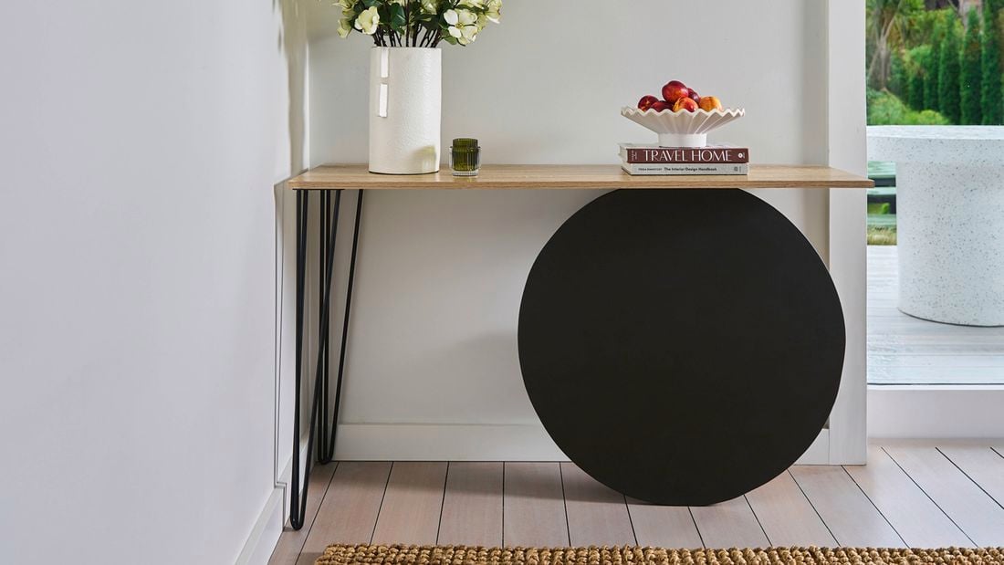 A hallway table storage solution near an entryway to a home.
