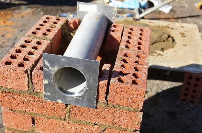 Pipe lying on top of bricks.