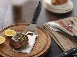 bbq accessories with a mince patty sitting on the splatter