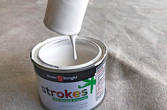 A piece of dowel that has been dipped in a small tin of paint