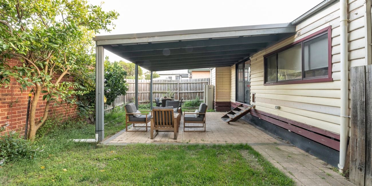 Pergola with cracked paving, outdoor setting and old weatherboards.