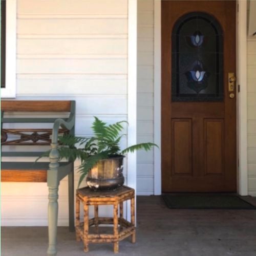 Maple stained front door, seat and stand with pot plant