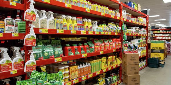 Garden care products displayed on shelving in a Bunnings store aisle, including weed killers, lawn food, pest control treatments, fertilisers and plant care solutions with visible pricing labels.