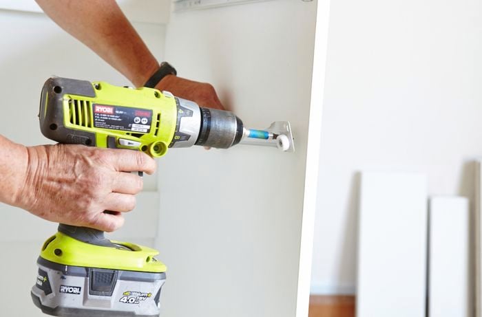 A person attaching a drawer runner using a cordless drill