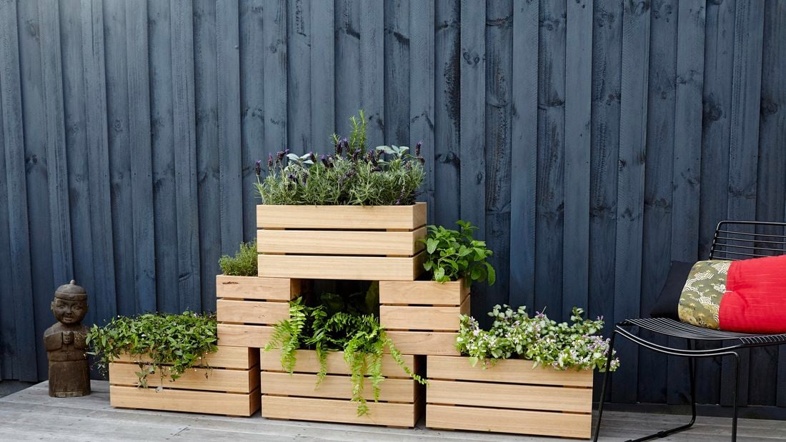 Six wooden planter boxes with plants stacked in a three-level pyramid