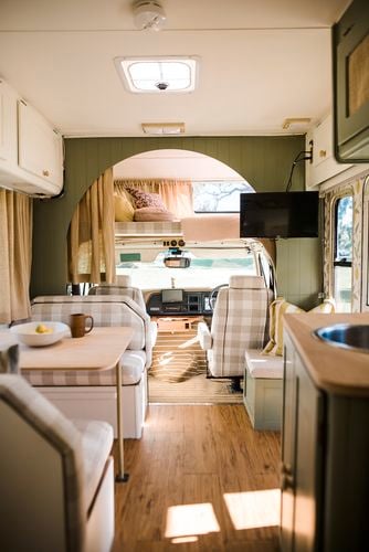 The interior of an RV caravan, decorated in green, plaid and timber.