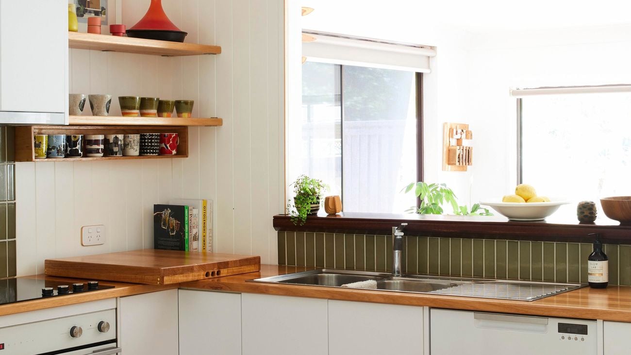 Modern and warm kitchen with timber benchtops and green tiles