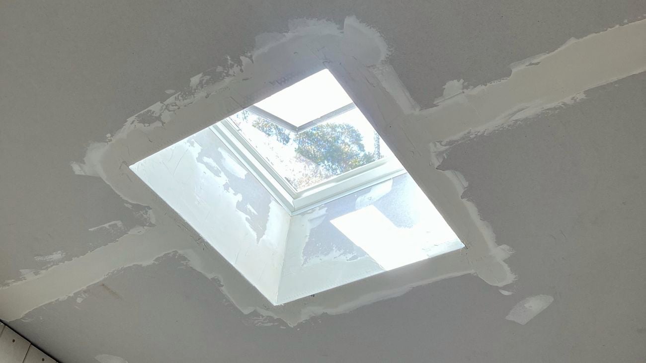 White ceiling under renovation with a square skylight.