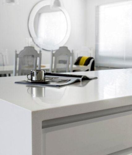 Close up of smooth white benchtop with magazine and coffee cup