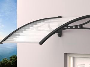 Metal framed window canopy above a door with a seascape in the background