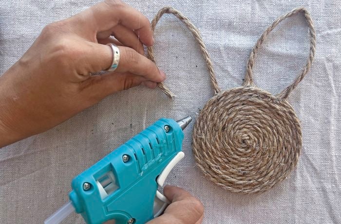 preson cutting a spiral of jute to make it look like bunny ears