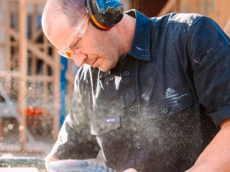  Construction worker wearing ear and eye protection working on his site