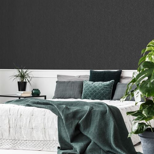 A bedroom with a black disco glitter wallpaper.