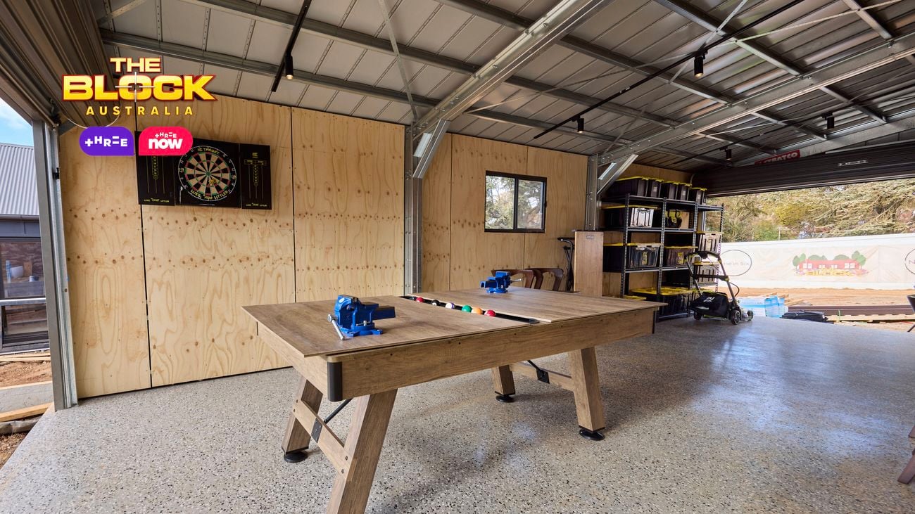 A garage with a saw on a wooden table in it.