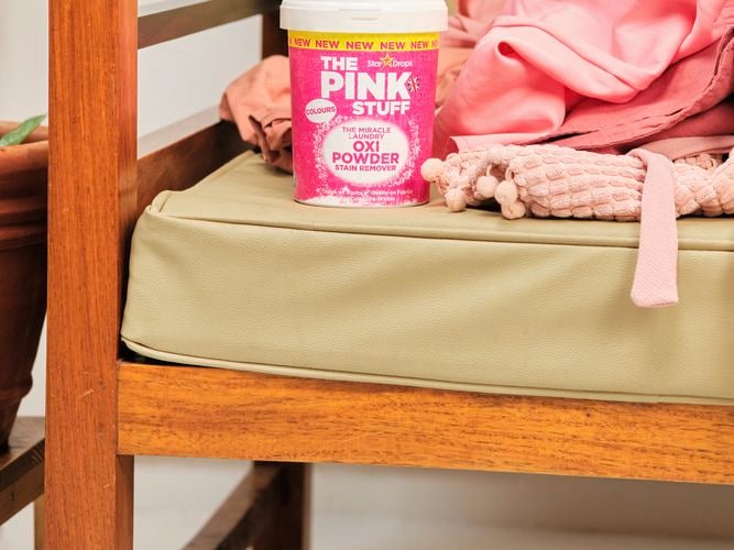 A container of Oxi Powder on a chair.