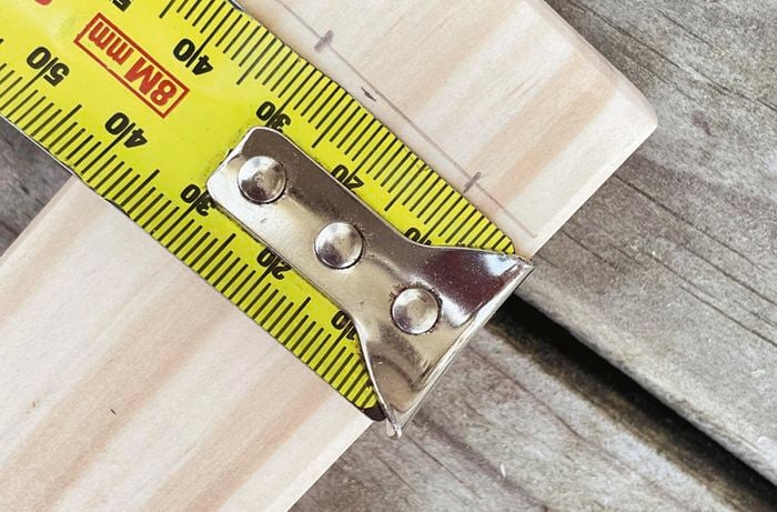 A piece of pine measured and marked ready to be cut