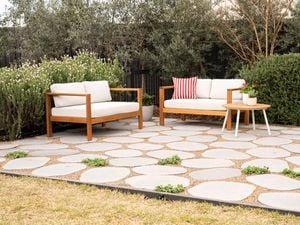 An outdoor patio showcases stepping stones with pebbles and greenery in between to fill the gaps
