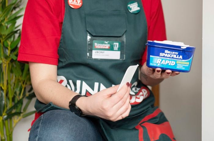 Bunnings team member Ebony with a tub of Spakfilla and a plastic applicator