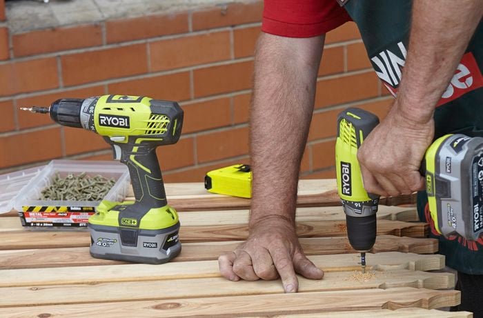 A person attaching pickets using a cordless driver