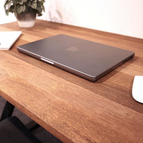 A laptop on a desk panel.